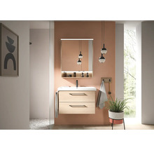 Salle de bains moderne avec meuble sous-lavabo suspendu en aspect bois clair, lavabo blanc, robinetterie noire et armoire de toilette éclairée.