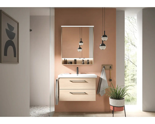 Salle de bains moderne avec meuble sous-lavabo suspendu en aspect bois clair, lavabo blanc, robinetterie noire et armoire de toilette éclairée.