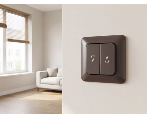 Interrupteur pour volets roulants marron foncé avec symboles de montée et descente sur un mur dans un salon lumineux.