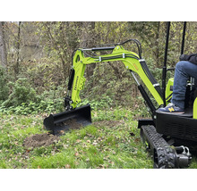 Mini-pelle Zipper lors de travaux de terrassement sur une pelouse avec un opérateur.