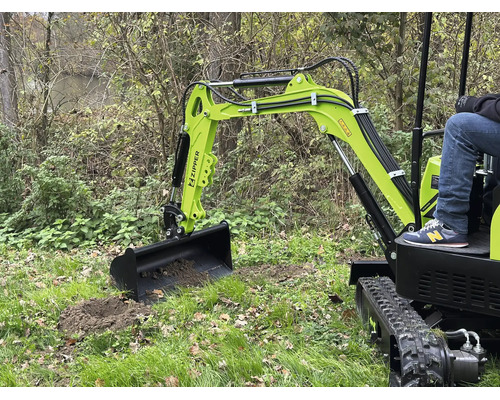 Mini-pelle Zipper lors de travaux de terrassement sur une pelouse avec un opérateur.
