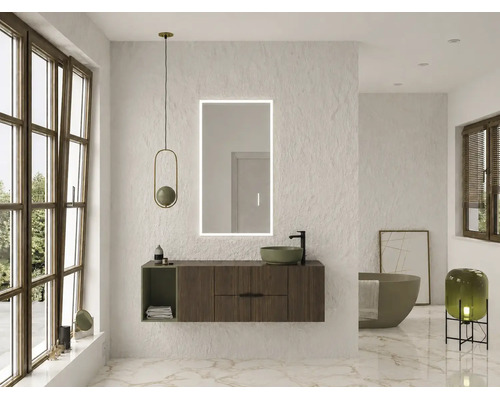 Salle de bains moderne avec meuble en bois sombre, miroir LED, vasque à poser verte et baignoire îlot devant un mur blanc texturé.