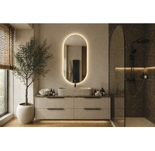 Salle de bains moderne avec meuble sous vasque clair, vasque à poser texturée, miroir ovale rétroéclairé et douche à l'italienne effet marbre sombre.