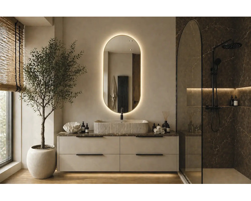 Salle de bains moderne avec meuble sous vasque clair, vasque à poser texturée, miroir ovale rétroéclairé et douche à l'italienne effet marbre sombre.