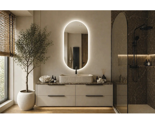Salle de bains moderne et lumineuse avec miroir ovale rétroéclairé, vasque à poser cannelée sur meuble et douche à l'italienne noire.