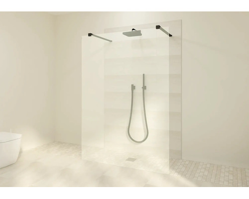 Douche à l'italienne avec paroi en verre, barres de stabilisation noires, pommeau de pluie et douchette dans une salle de bain moderne.