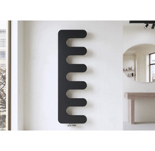 Radiateur design noir moderne en forme de peigne sur un mur dans une pièce lumineuse et ordonnée.