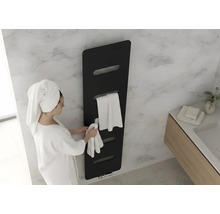 Sèche-serviette noir dans une salle de bain moderne avec mur en marbre. Une femme en peignoir suspend une serviette.