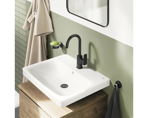 Salle de bain moderne avec vasque à poser blanche, mitigeur noir mat et meuble sous-vasque en bois.