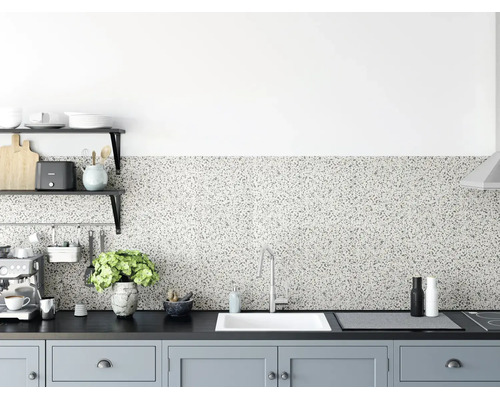 Fond de hotte aspect terrazzo dans une cuisine moderne avec plan de travail sombre, évier blanc et éléments gris clair.