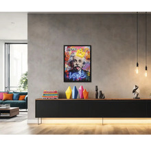 Salon moderne et lumineux avec un tableau pop art encadré d Albert Einstein au-dessus d un buffet noir avec des vases colorés.