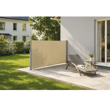 Store latéral moderne en tissu servant de brise-vue et de pare-vent sur une terrasse en pierre avec chaise longue et gazon.