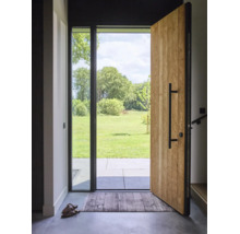 Porte d'entrée ouverte en bois avec poignée barre noire et élément vitré, vue sur une terrasse et une pelouse verte avec des arbres.