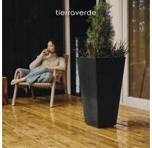 Grand bac à fleurs carré et conique en noir sur une terrasse en bois avec une plante. Tierraverde Logo.
