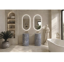 Salle de bain moderne avec deux lavabos colonnes en pierre à motifs, miroirs ovales rétroéclairés, baignoire îlot et robinetterie dorée.