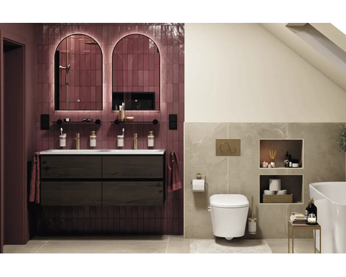 Salle de bains moderne avec meuble double vasque en bois, deux miroirs cintrés rétroéclairés, WC suspendu et carrelage aspect pierre.