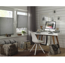 Modernes Arbeitszimmer mit grauen Plissees an den Fenstern, weißem Schreibtisch, hellem Holzfußboden und Wandverkleidung.
