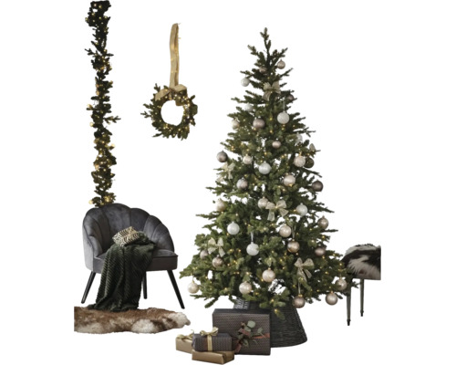 Geschmückter künstlicher Weihnachtsbaum mit Christbaumkugeln und Lichterkette neben einem Sessel, Kranz, Girlande und Geschenken.