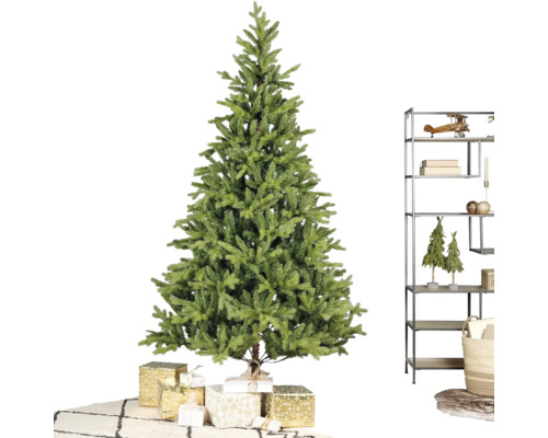 Künstlicher Weihnachtsbaum an engem helle Raum mat agewéckelte Cadeauen, engem modernen Metallregal an engem Teppech mat Muster.