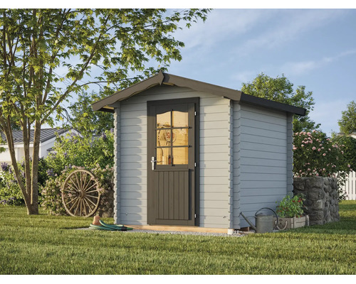 Abri de jardin gris en bois avec toit à deux pans et porte simple munie d'une fenêtre à croisillons dans un jardin clair.