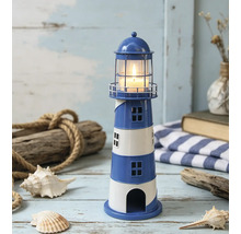 Porte-bougie chauffe-plat en forme de phare marin en métal, rayures bleues et blanches, avec bougie allumée et décorations maritimes.