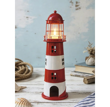 Photophore en métal en forme de phare à rayures avec bougie allumée dans un décor maritime avec corde et coquillages.