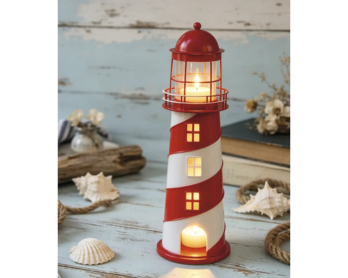 Photophore décoratif en forme de phare pour bougies chauffe-plat dans une scène maritime avec coquillages, corde et vieux bois.