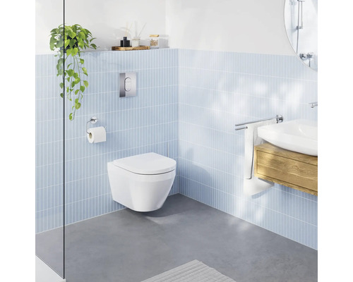 Modernes Badezimmer mit wandhängendem Tiefspül-WC, hellblauen Wandfliesen, grauem Boden und Waschbecken mit Holzunterschrank.