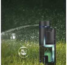 Pulvérisateur de jardin sur une pelouse émettant une brume d'eau. La vue en coupe montre une capsule interne et des icônes de protection des plantes.