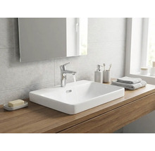 Salle de bains moderne avec une vasque à poser en céramique blanche sur un plan en bois, un robinet chromé et un miroir.