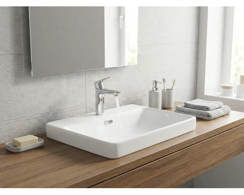 Salle de bains moderne avec une vasque à poser en céramique blanche sur un plan en bois, un robinet chromé et un miroir.