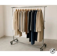 Portant à vêtements mobile en métal sur roulettes avec barre réglable en hauteur et vêtements sur cintres en bois. (Image AI modified or generated)