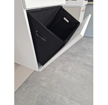 Meuble sous-vasque avec tiroir basculant ouvert et panier à linge en textile noir.