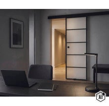 Un bureau avec un bureau, une lampe de bureau à LED et une porte coulissante moderne en verre avec un cadre noir. (Image AI modified or generated)