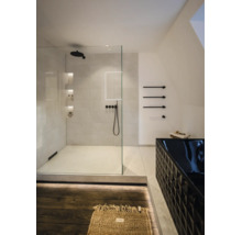 Salle de bains moderne avec douche à l'italienne en verre, robinetterie noire et baignoire noire à motif géométrique.