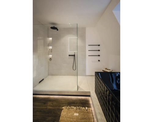 Salle de bains moderne avec douche à l'italienne en verre, robinetterie noire et baignoire noire à motif géométrique.