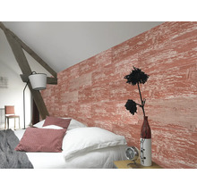 Chambre à coucher lumineuse avec mur structuré à l'aspect bois rouge, literie blanche, poutre en bois rustique et lampadaire moderne.