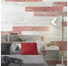 Mur de chambre avec des panneaux horizontaux aspect bois vieilli en blanc et rouge, lit avec coussins, étagère et lampadaire.