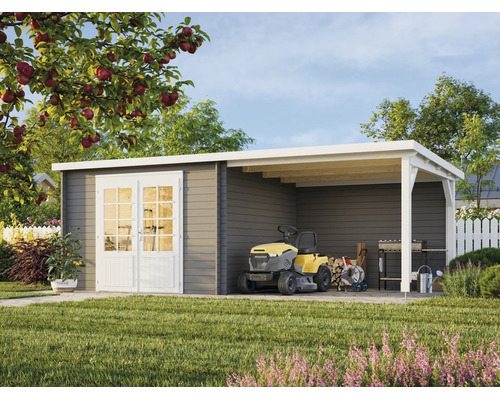 Abri de jardin moderne en bois gris avec doubles portes blanches et auvent. Sous l'auvent se trouvent un tracteur tondeuse et des outils.