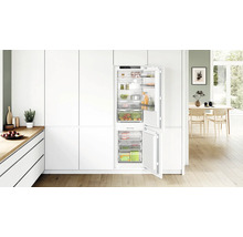 Cuisine équipée moderne avec réfrigérateur congélateur intégré, doté de compartiments et tiroirs pour un rangement organisé des aliments.