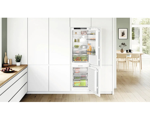 Cuisine équipée moderne avec réfrigérateur congélateur intégré, doté de compartiments et tiroirs pour un rangement organisé des aliments.
