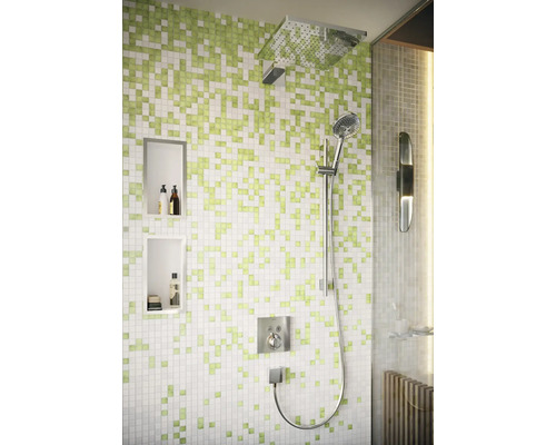 Moderne Dusche mit quadratischem Duschkopf und Handbrause vor einer Wand mit Mosaikfliesen in Pixeloptik und integrierten Wandnischen.