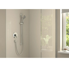 Moderne Dusche mit Unterputz Einhebelmischer, Handbrause und Duschstange an einer hellen Fliesenwand in einem Badezimmer.