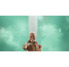 Une femme souriante prend une douche sous un jet d eau constant.
