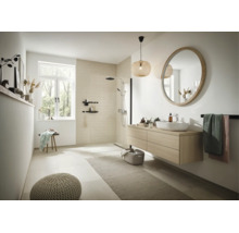 Salle de bains moderne avec douche à l'italienne, meuble sous vasque en bois, miroir rond et lampe suspendue décorative dans un espace clair.
