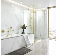 Modernes Badezimmer mit Marmoroptik Fliesen, Badewanne, bodengleicher Glasdusche und goldenen Armaturen bei Tageslicht.