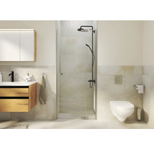 Salle de bains moderne avec douche en verre, meuble vasque en bois, toilettes suspendues et robinetterie de douche sombre dans une pièce carrelée.