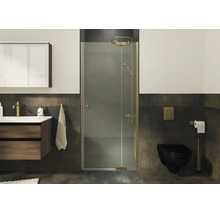 Cabine de douche moderne avec porte battante et profilés finition laiton dans une salle de bain élégante.