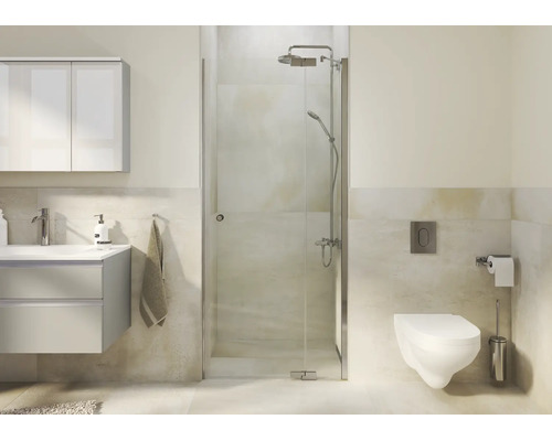 Salle de bain moderne avec cabine de douche en verre, lavabo et toilettes murales dans un environnement lumineux.