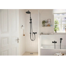 Helles Badezimmer mit ebenerdiger Dusche und Badewanne inklusive schwarzer Armaturen und moderner Einrichtung.